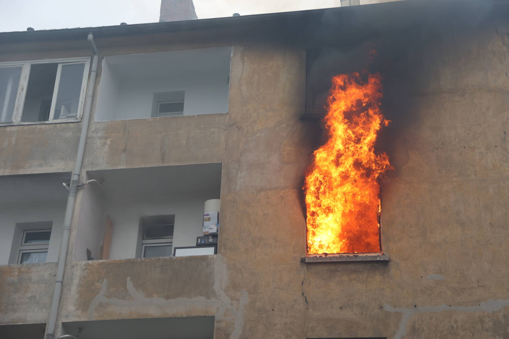 Flammen schlagen aus Mehrfamilienhaus