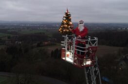 Weihnachtsmann mit Tannenbaum auf Drehleiter