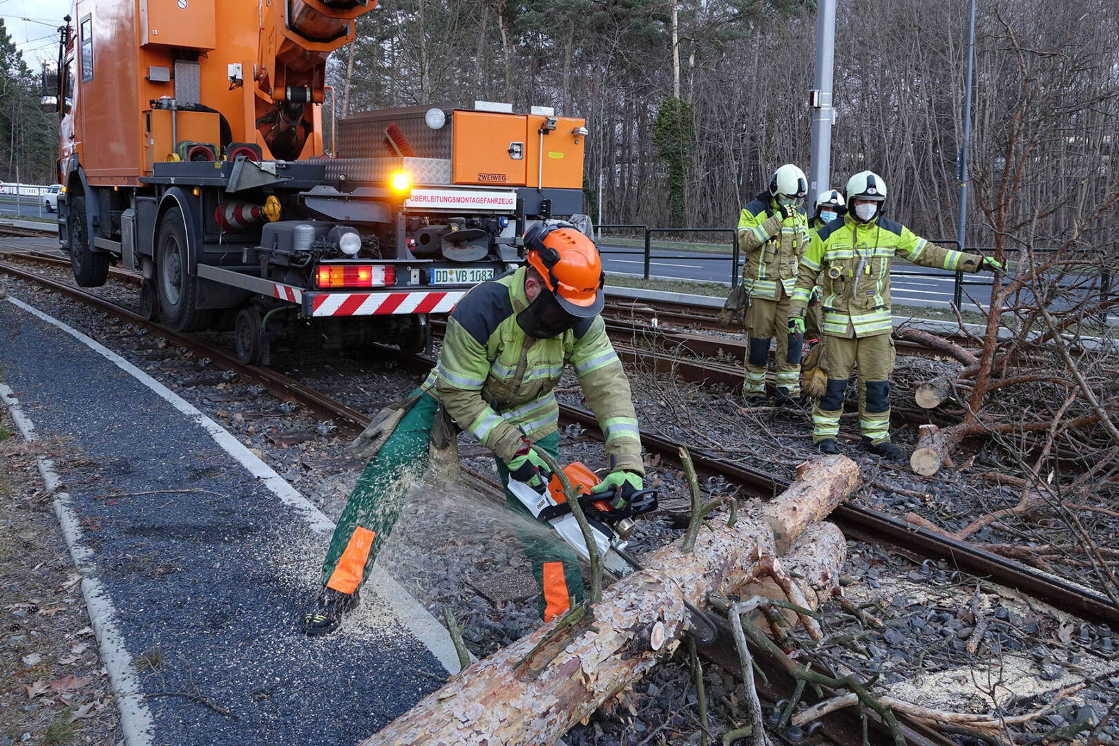 Einsatzkräfte beseitigen einen umgestürzten Baum aus dem Gleisbereich der Dresdner
