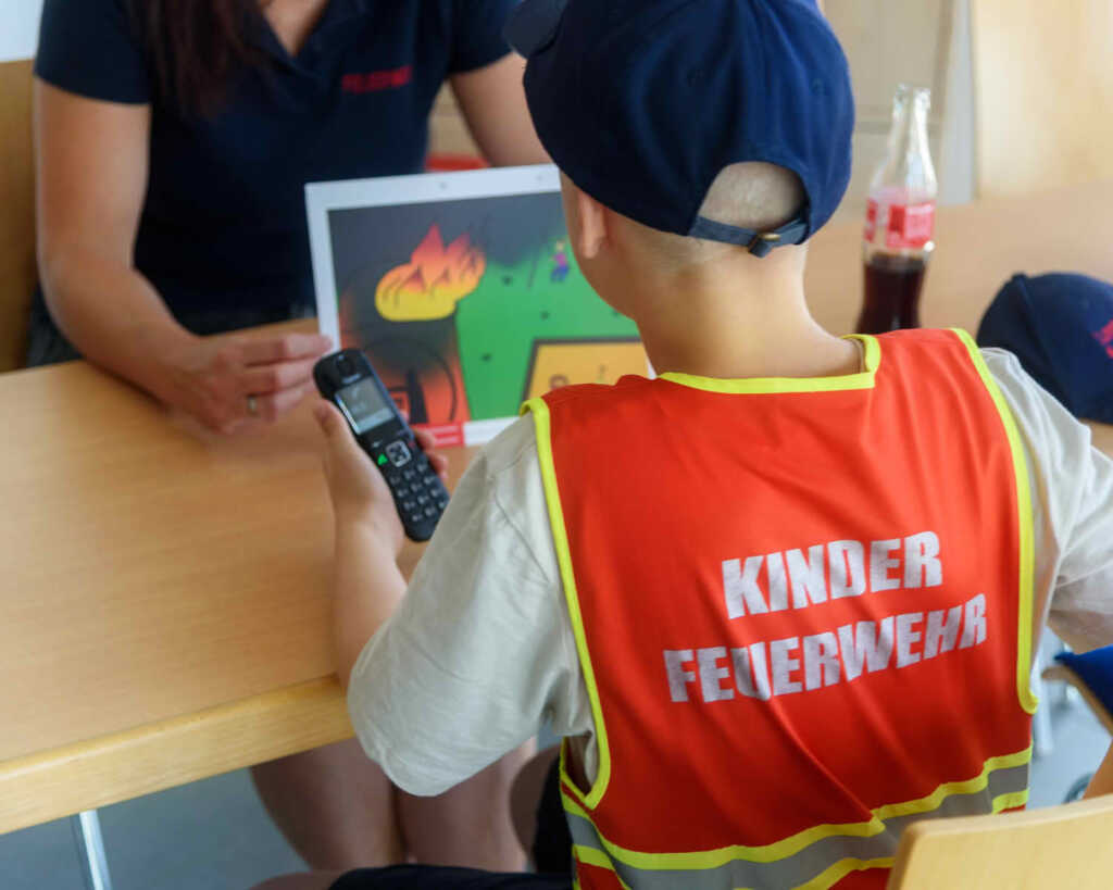 Ein Mitglied der Kinderfeuerwehr setzt einen Notruf in der Prüfung zur Kinderflamme ab.