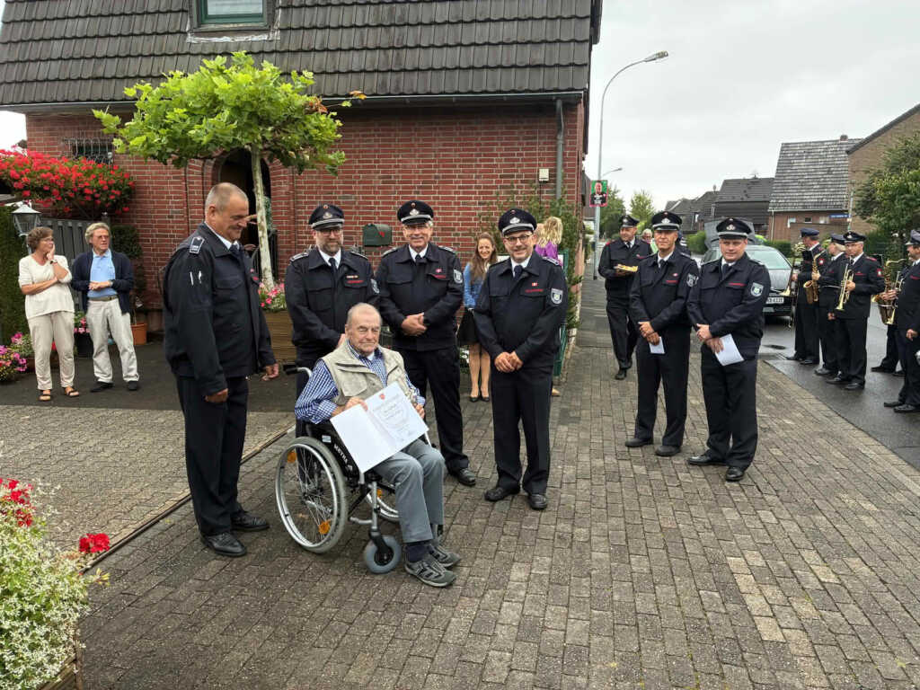 Gruppenfoto mit geehrtem Mann im Rollstuhl