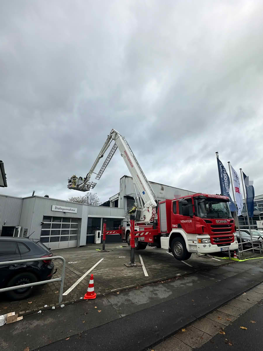 Großbrand in einer Autowerkstatt an der Kölner Straße 12 Der Gelenkmast der Werkfeuerwehr Venator unterstützt die Nachlöscharbeiten an der Kölner Straße. Über den Korb werden schwer zugängliche Dachbereiche gezielt kontrolliert.