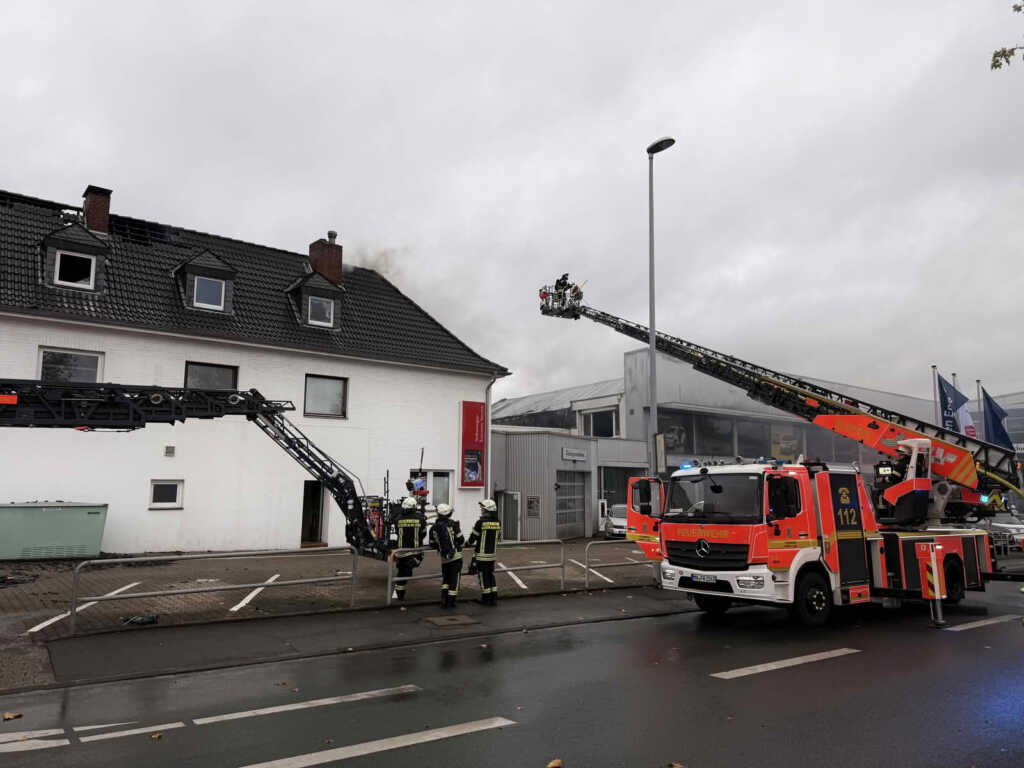 Großbrand in einer Autowerkstatt an der Kölner Straße 11 Mit Drehleitern öffnen Einsatzkräfte Dachbereiche, um verbliebene Glutnester zu lokalisieren und abzulöschen.