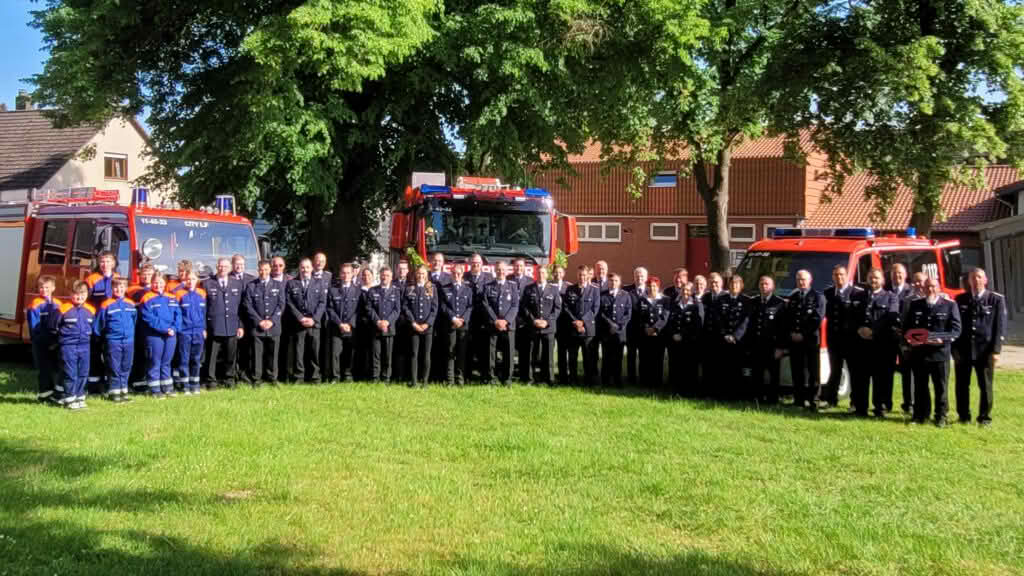 Feuerwehrmannschaft vor Fahrzeugen versammelt
